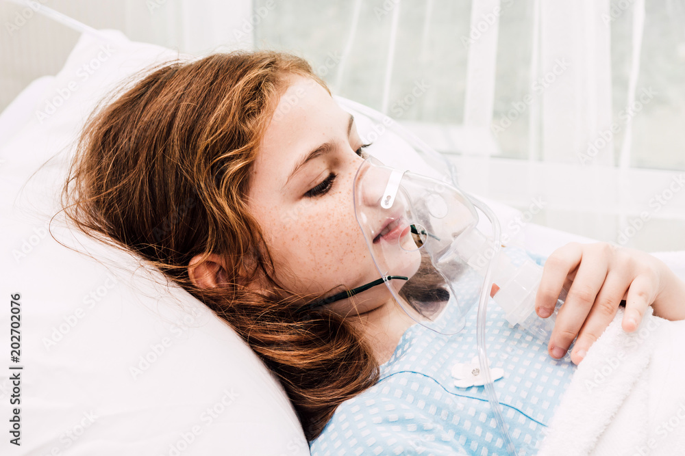 Cute little girl oxygen mask on her face on bed in the hospital Stock ...