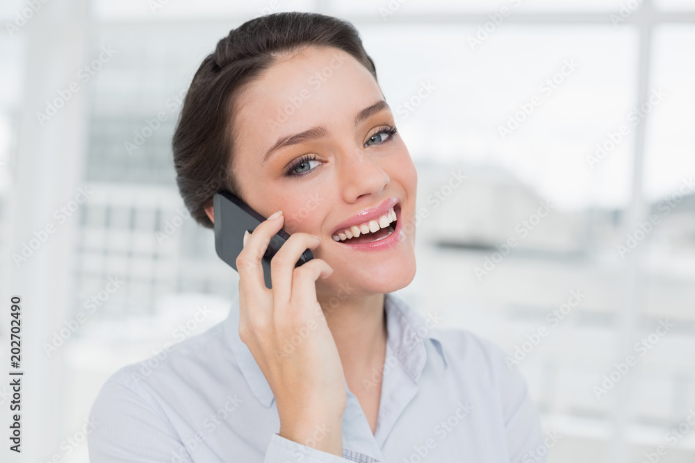 Cheerful elegant young businesswoman using cellphone Cheerful elegant young businesswoman using cellphone