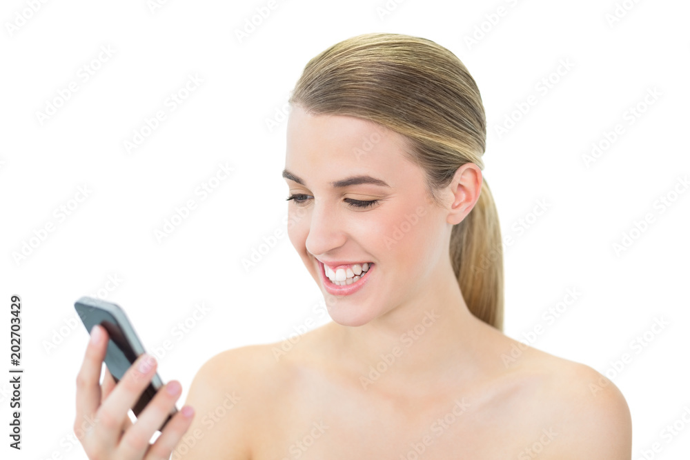 Happy attractive blonde reading a message on her smartphone Happy attractive blonde reading a message on her smartphone