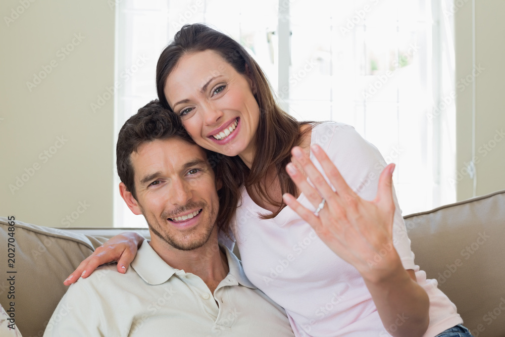 Happy woman showing engagement ring besides man Happy woman showing engagement ring besides man