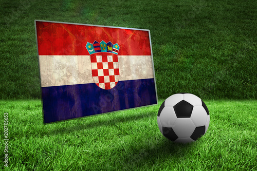 Black and white football on grass against croatia flag in grunge effect