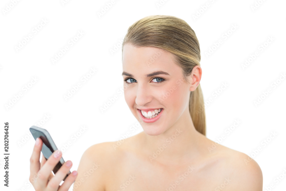 Smiling attractive blonde holding her smartphone Smiling attractive blonde holding her smartphone