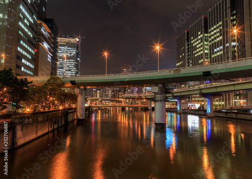Bridges and highways cross a waterway at night in central Osaka