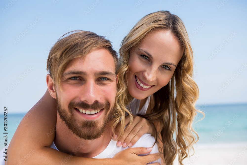 Fototapeta premium Close up portrait of boyfriend piggybacking girlfriend