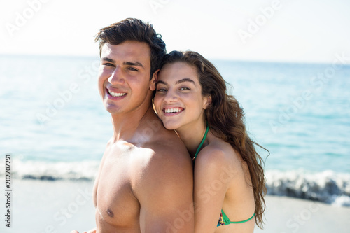 Young couple embracing while standing at beach