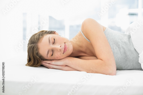 Calm sleeping woman lying in her bed 