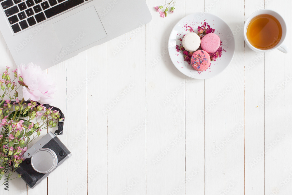 Φωτογραφία Isolated flat view of white wooden desk with gray open metal laptop, pink flower