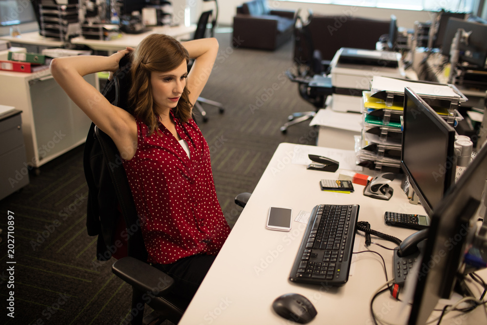 Young businesswoman relaxing at desk in office Young businesswoman relaxing at desk in office