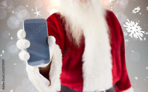 Santa claus showing smartphone against grey design with snowflakes
