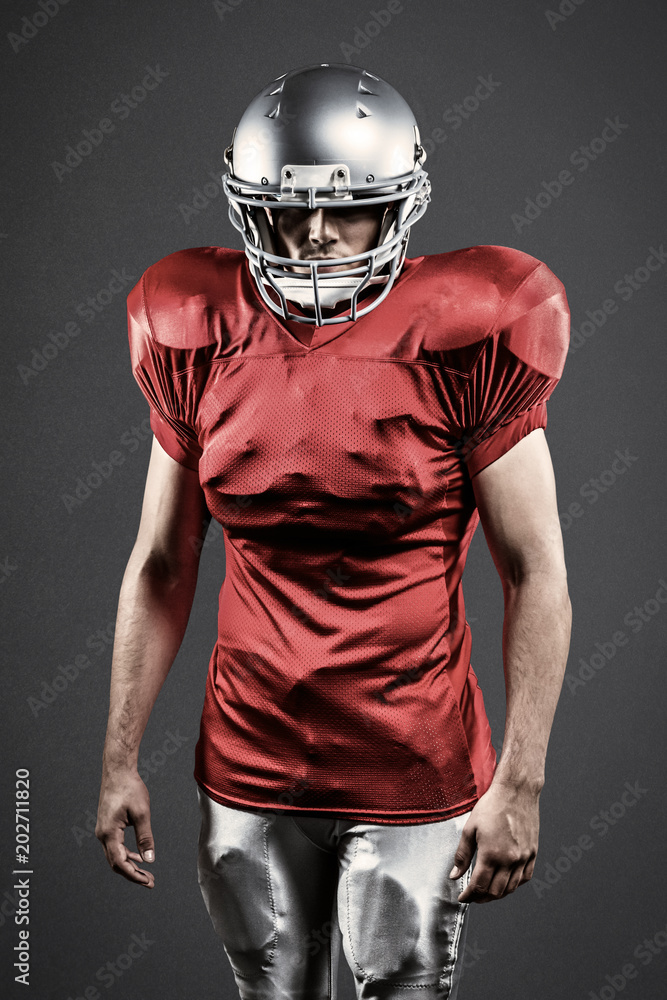 Confident American football player against grey