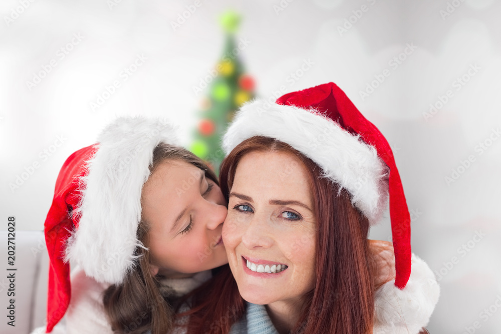Mother and daughter against blurry christmas tree in room Mother and daughter against blurry christmas tree in room