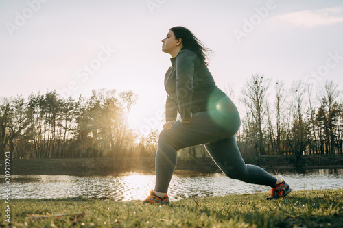 Overweight woman warming up before jogging