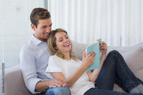 Relaxed couple reading book on couch