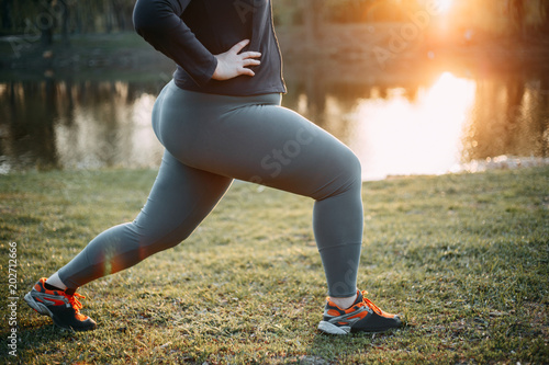 Overweight woman training legs before jogging