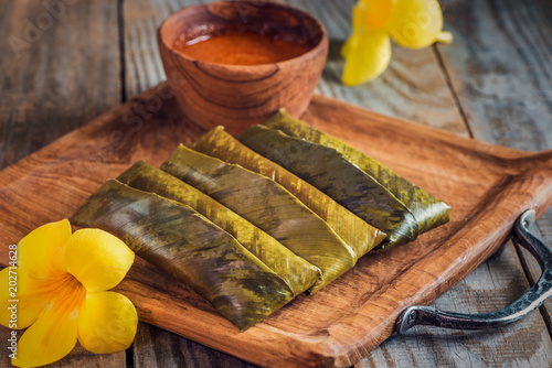 sticky rice wrapped in leaves and served with peanut sauce. Famous cuisine in Borneo. Brunei, Sarawak and Sabah. Called Kelupis. photo