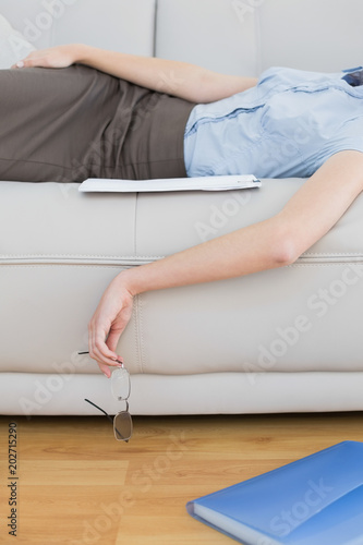 Mid section of slender classy businesswoman lying on couch sleeping