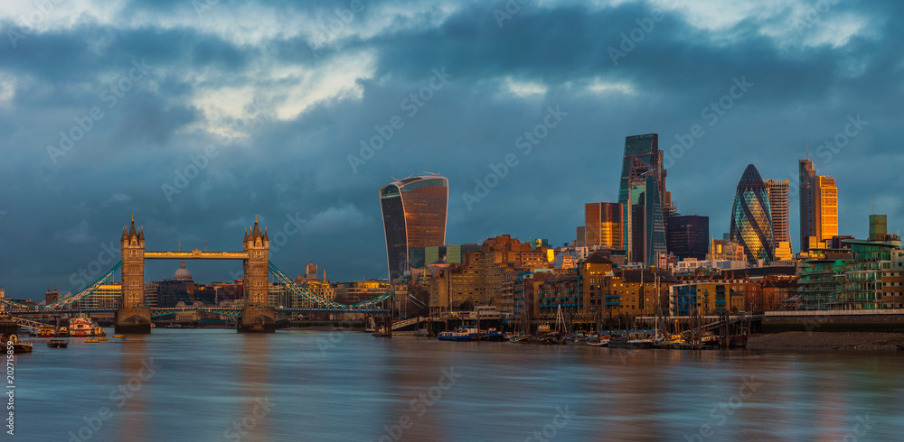 Φωτογραφία London, England - Panoramic skyline view of London with Tower Bridge, skyscrapers of Bank District and other landmarks at golden hour sunrise