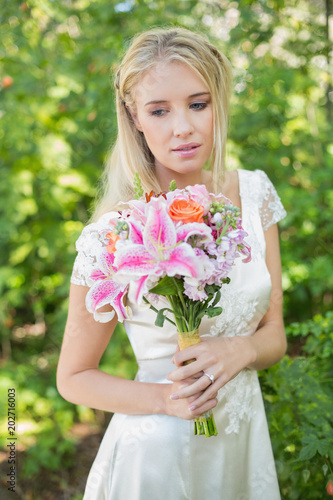 Blonde smiling bride holding bouquet