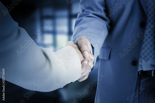 People in suit shaking hands against college photo