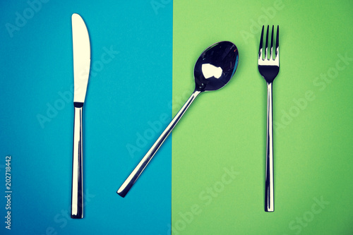spoon  knife and fork on blue and green ground