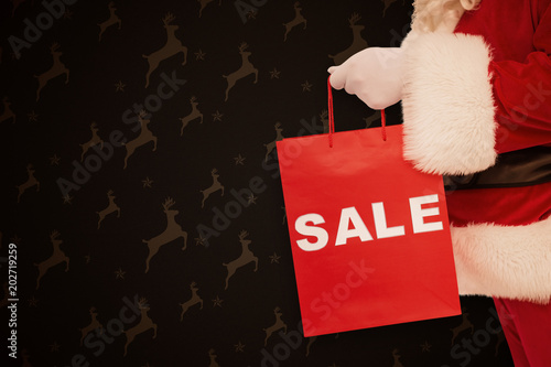 Wallpaper Mural Santa claus holding sale bag  against grey reindeer pattern Torontodigital.ca