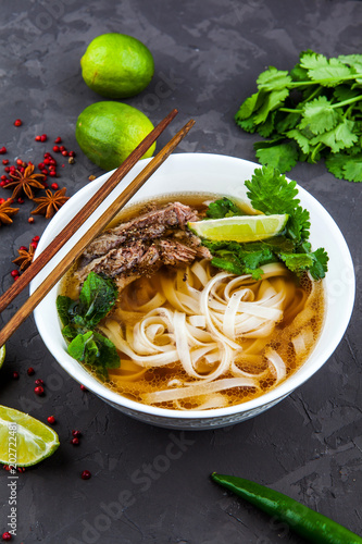 Vietnamese Pho Noodle Soup. Beef with Chilli, Basil, Rice Noodles, Bean Shoots showing noodles