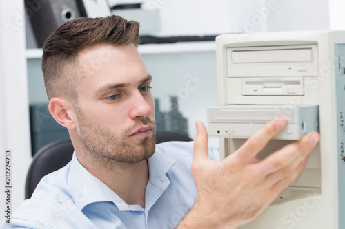 Computer engineer inserting cddvd player into computer case photo