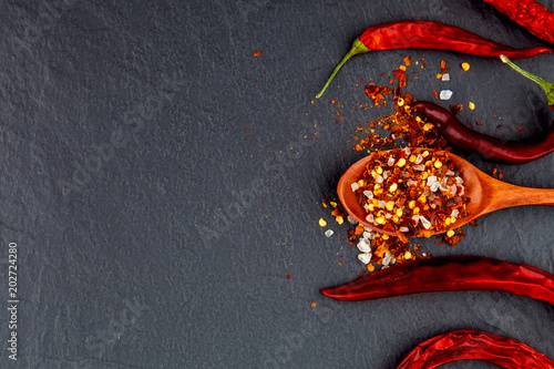 Red and yellow chili pepper dried. On a stone black background.