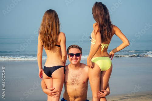 happy man hugging women on the beach