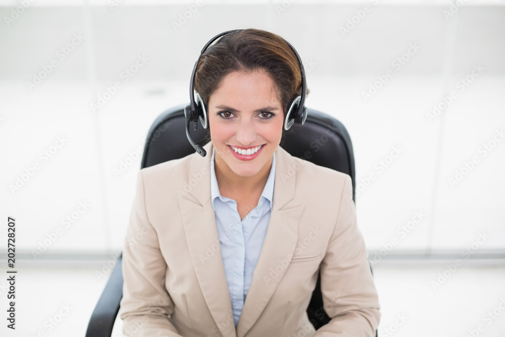 Smiling call center agent sitting in swivel chair Smiling call center agent sitting in swivel chair