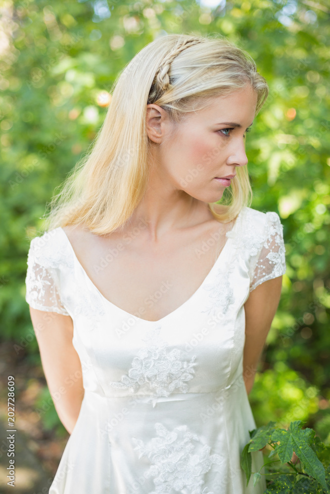 Content beautiful blonde bride with hands behind back Content beautiful blonde bride with hands behind back