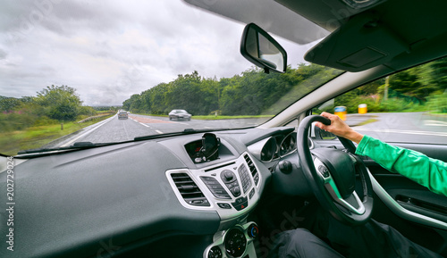 Konstfotografi A female driver driving a car along a busy road on an English single carriageway on a cloudy overcaste day