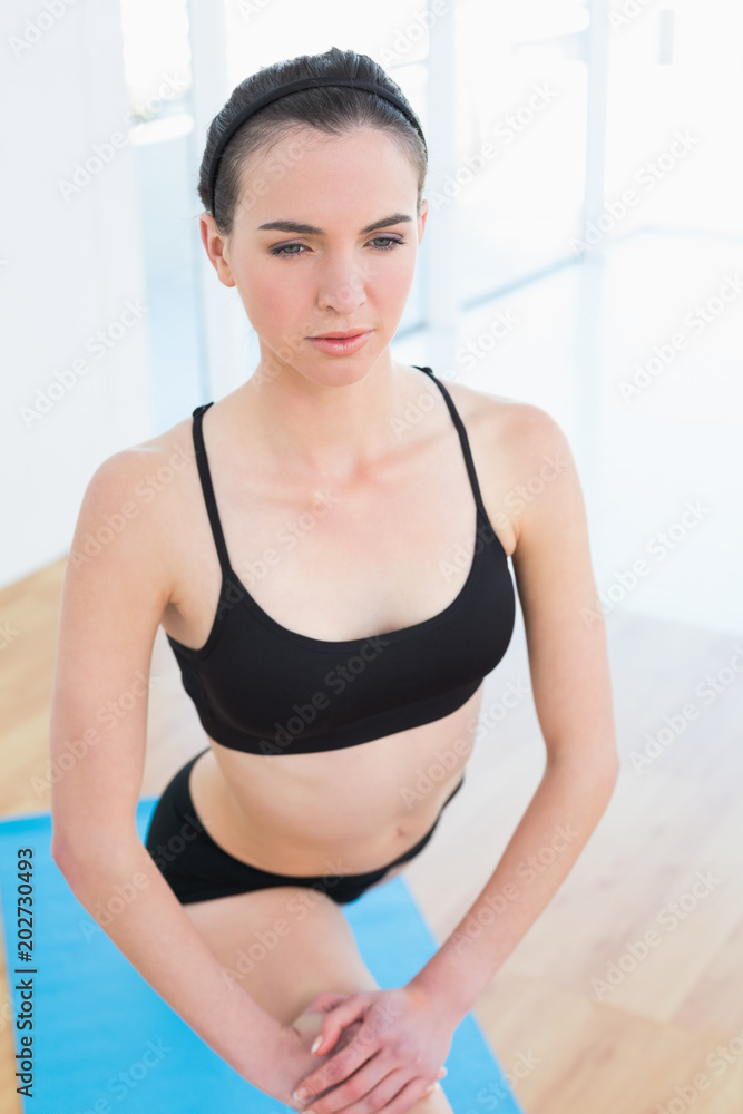 Fit young woman stretching leg in fitness center