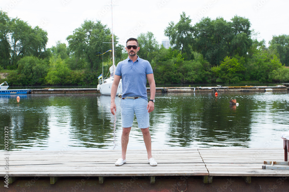 Captain in the tourist travel. Pending the ship at the pier. man in sunglasses pending the boat. Man's style. dressing shirt, glasses Captain in the tourist travel. Pending the ship at the pier. man in sunglasses pending the boat. Man's style. dressing shirt, glasses
