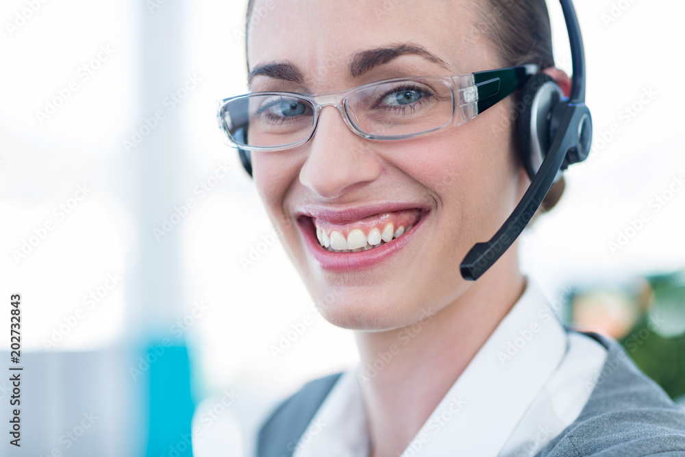 Happy businesswoman looking at camera with headset 