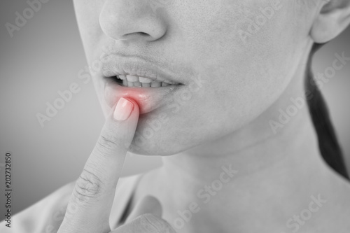 Woman pointing her lip against grey vignette