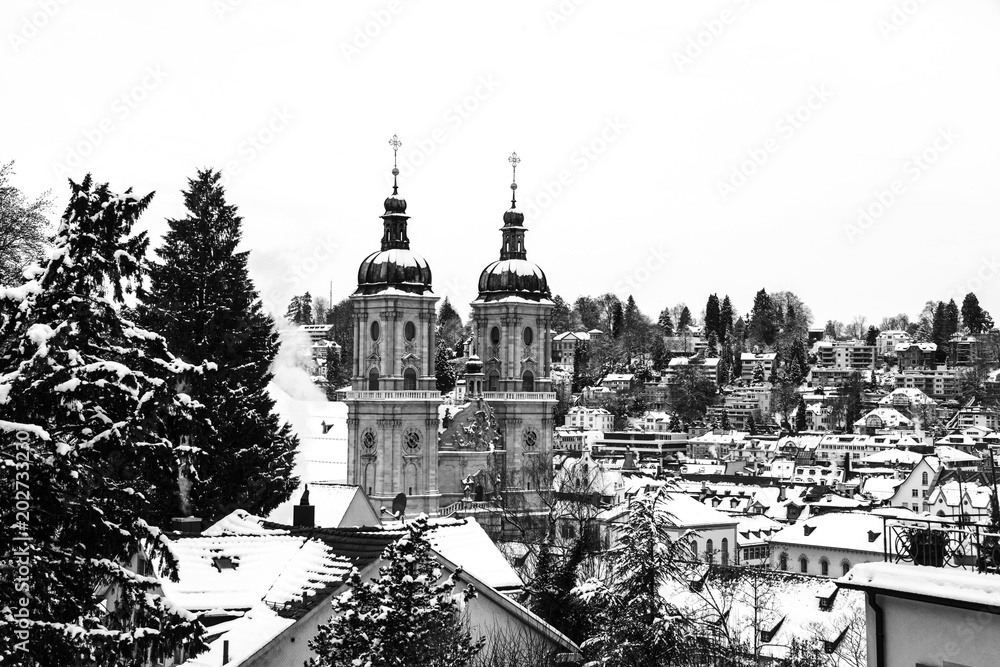 Aerial view of historical buildings covered in snow in winter. Cathedral in St Gallen, Switzerland. Black and white