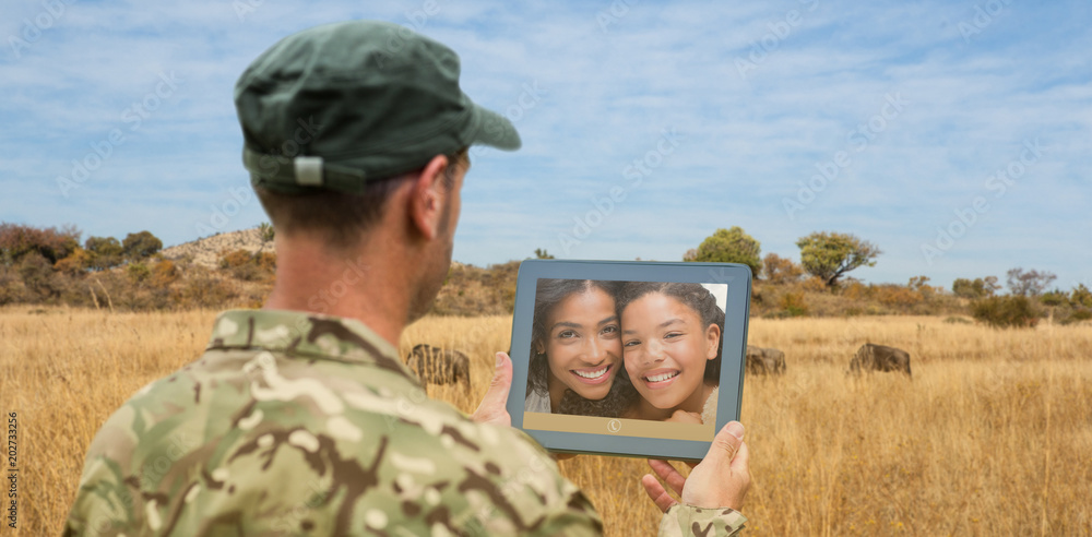 Fototapeta premium Soldier using tablet pc against landscape with animals