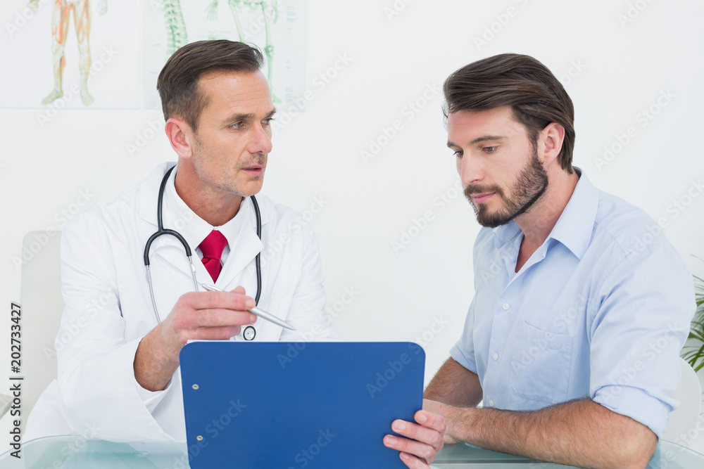Doctor discussing reports with patient at medical office Doctor discussing reports with patient at medical office