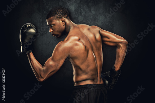 Muscular boxer against dark background © vectorfusionart