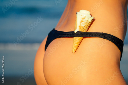 Fotografie soft ice cream and sexy hip young woman on the beach