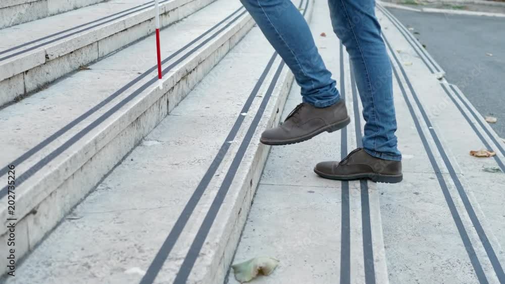 Blind man's legs climbing stairs helped by his cane Blind man's legs climbing stairs helped by his cane