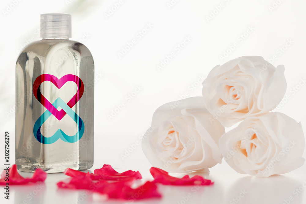 Linking hearts against glass flask with petals and roses Linking hearts against glass flask with petals and roses
