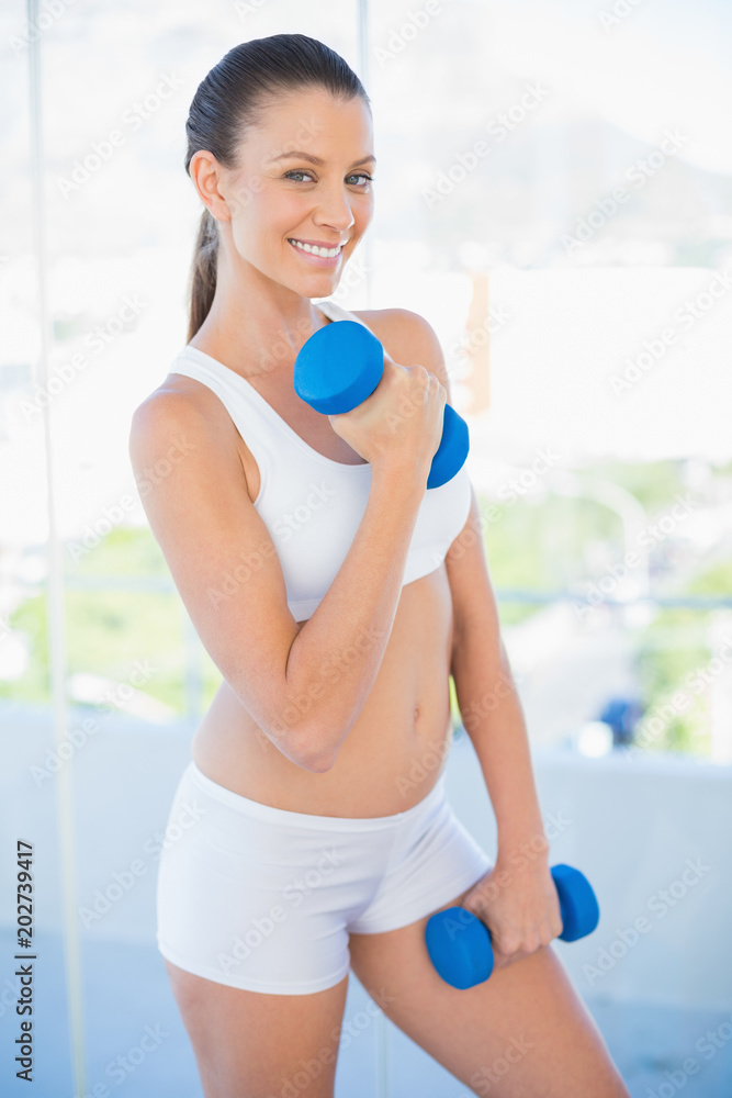 Happy woman lifting dumbbell
