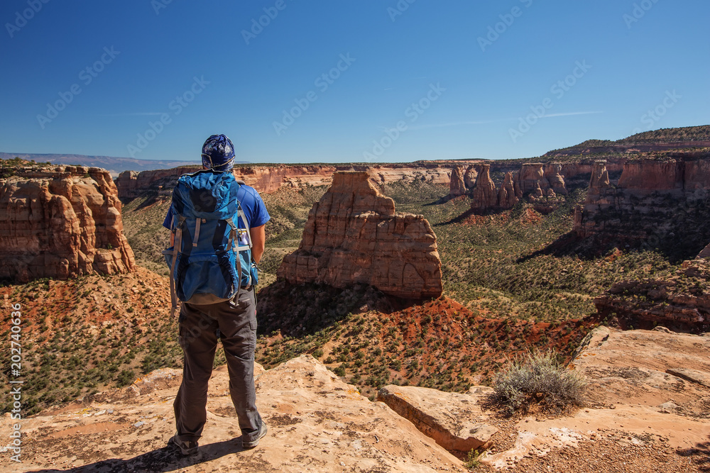 Hiker is sitting on the cliff in Colorado National monument, USA Hiker is sitting on the cliff in Colorado National monument, USA