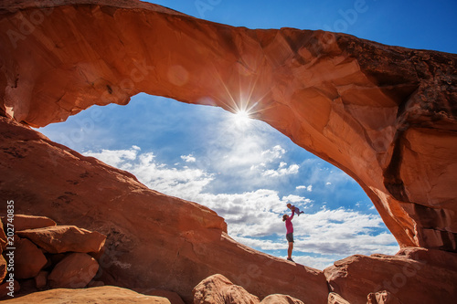 Stampa su tela Mother with her baby son stay below Skyline arch in Arches National Park in Utah