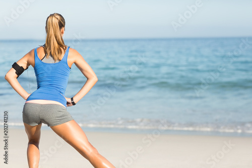 Wear view of fit woman stretching her leg 