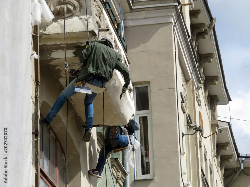 Εκτύπωση καμβά Workers repairs the facade of the building