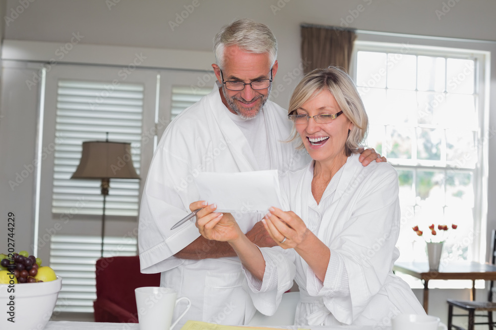 Obraz premium Cheerful couple looking at a document at home