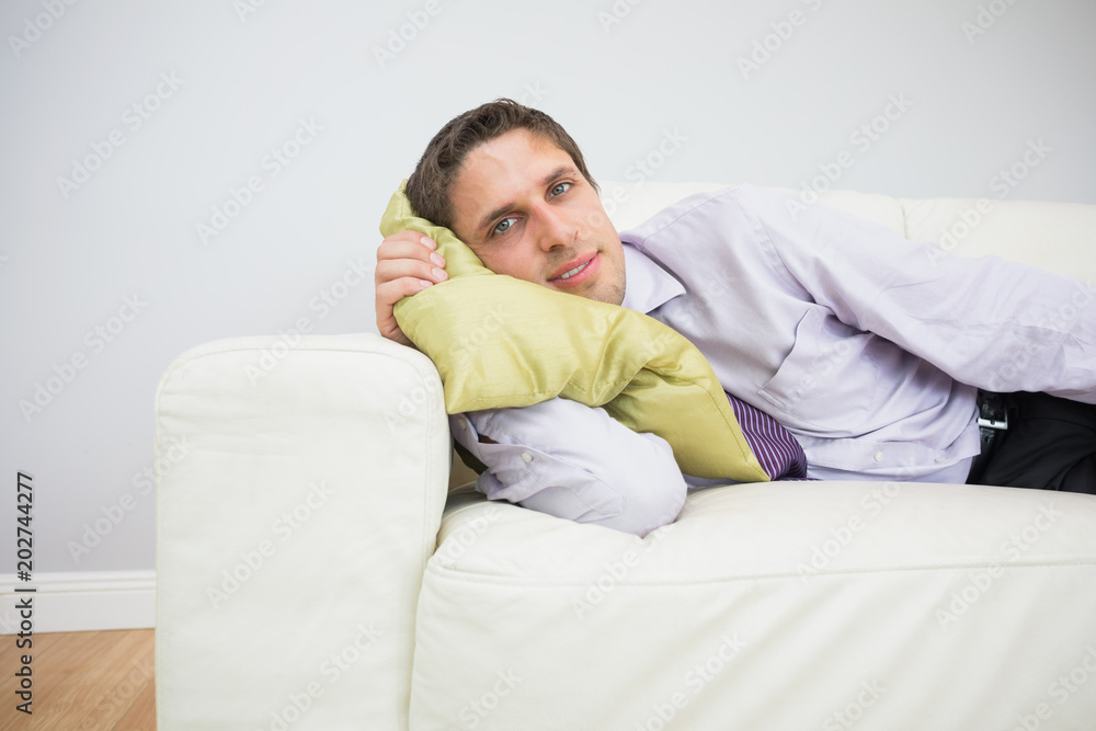 Portrait of a businessman lying on sofa in living room